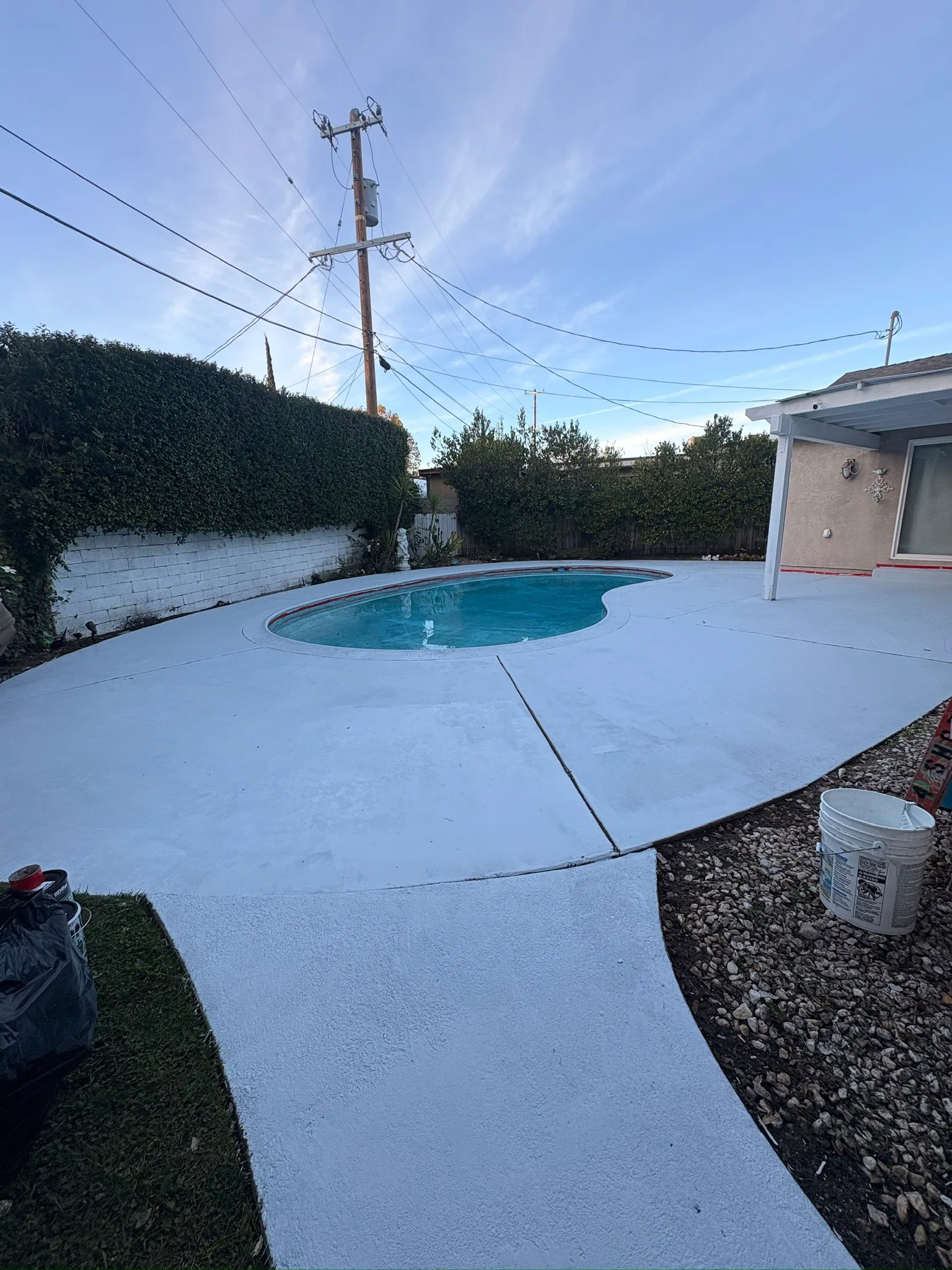 Freshly finished concrete pool deck around a backyard pool