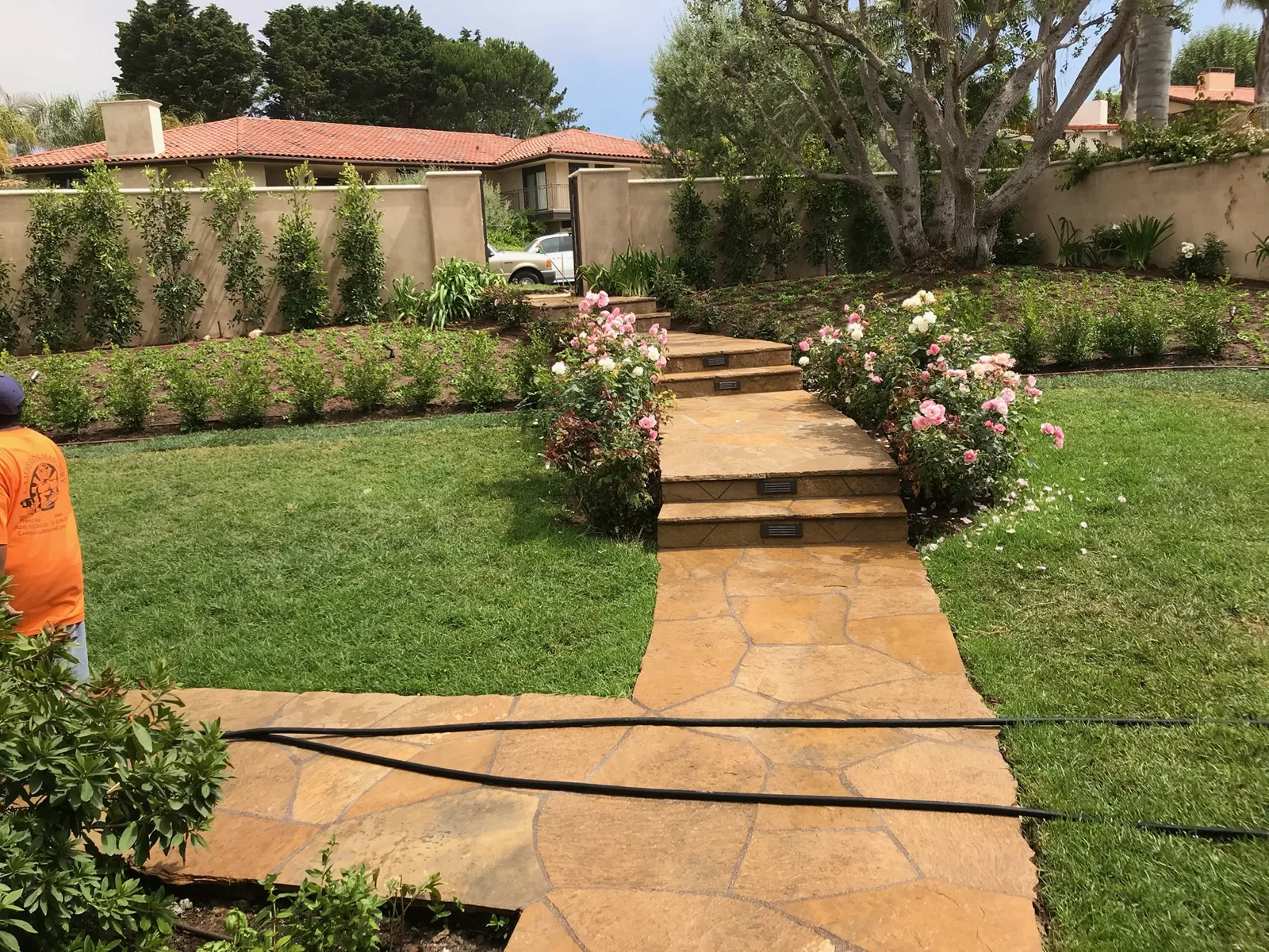 Flagstone path through a lawn beside roses, built by Camberos Masonry